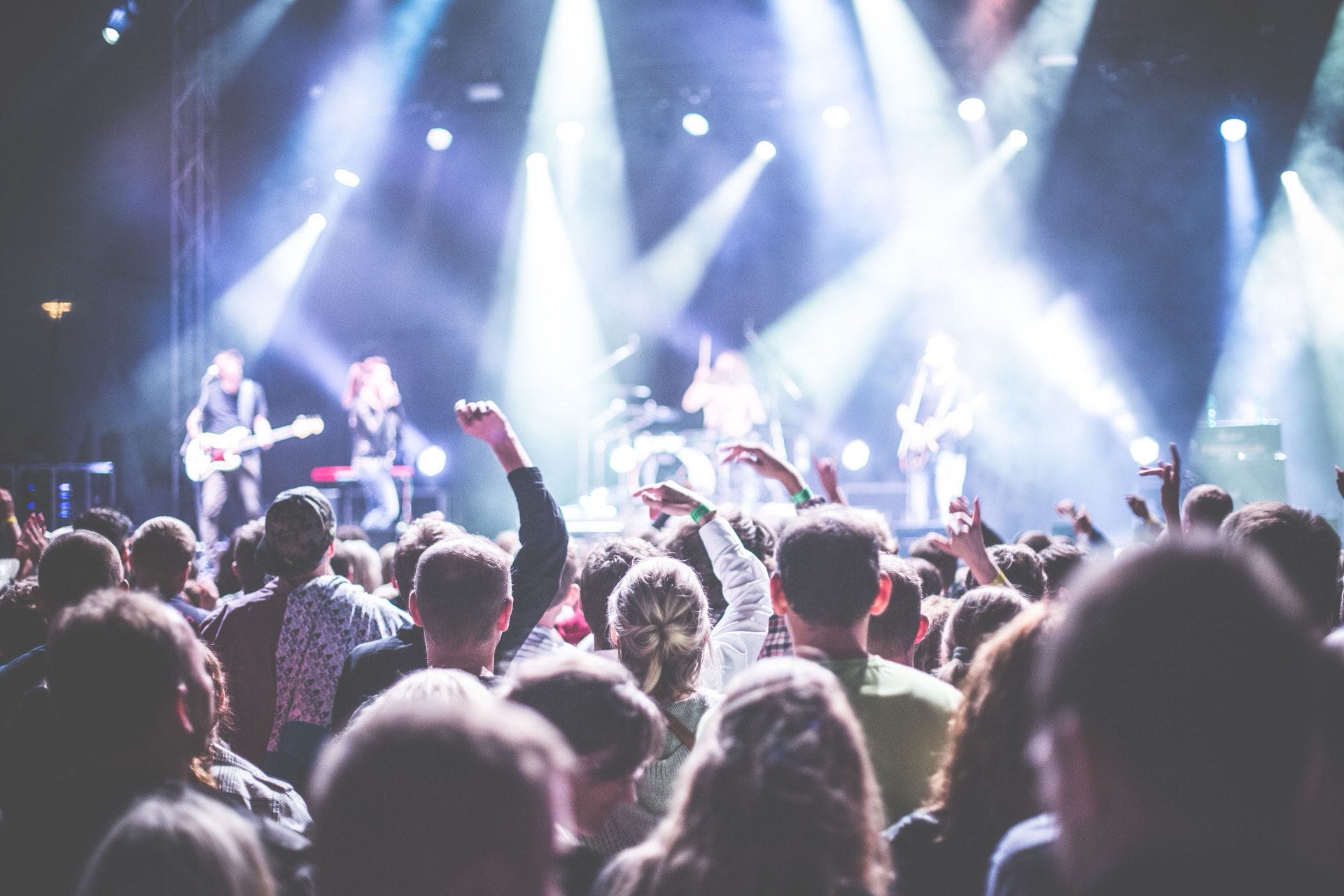 A crowd in front of a live band performing at night
