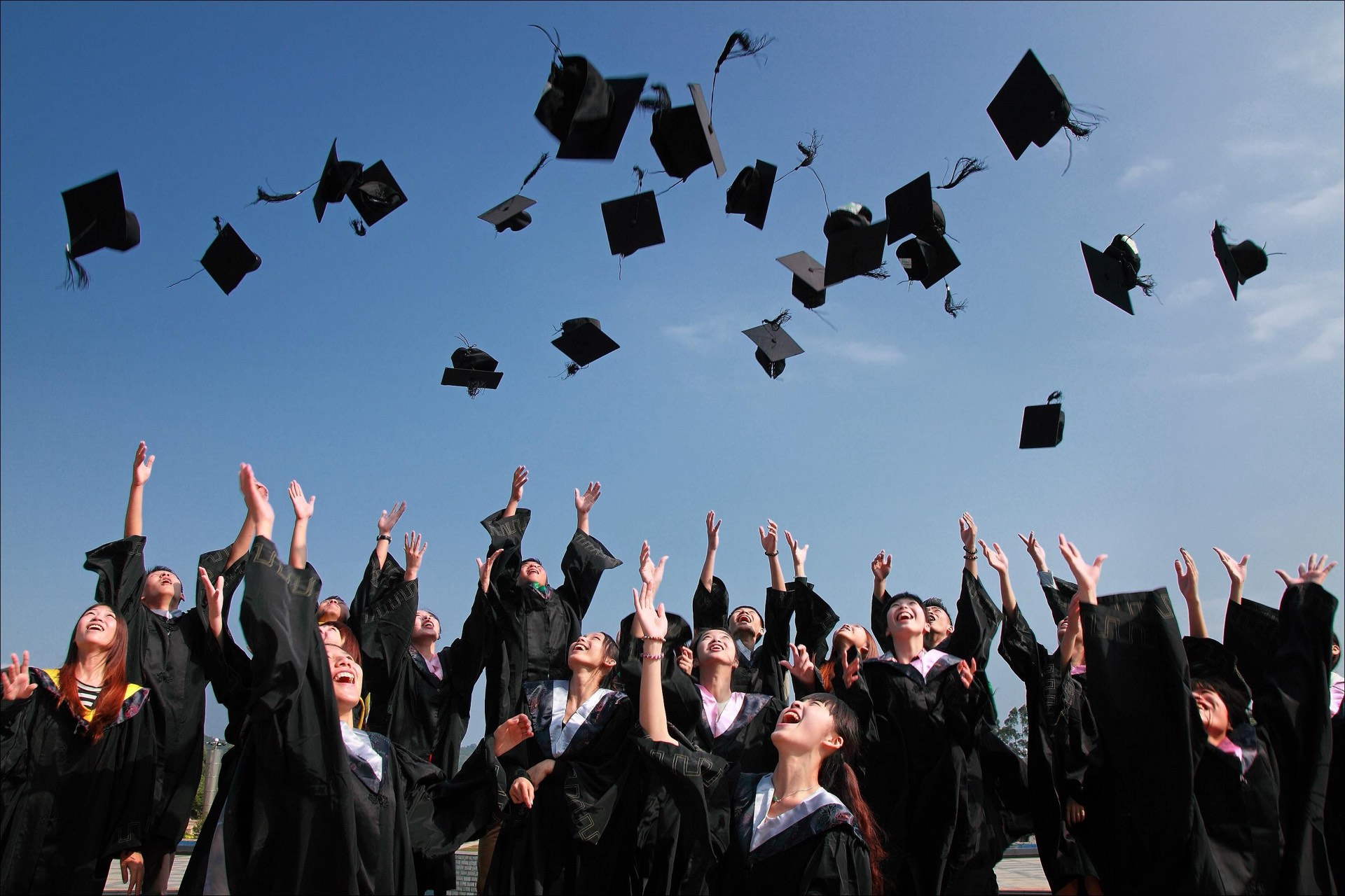 Graduates joyfully throwing their caps into the air