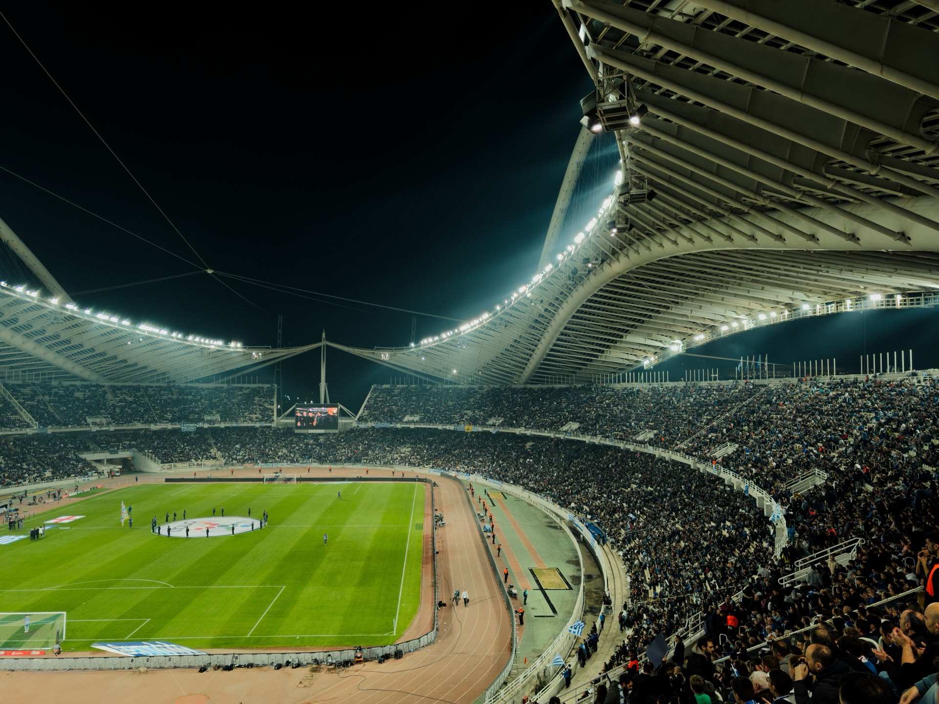 A packed illuminated stadium at night, ready for a live event