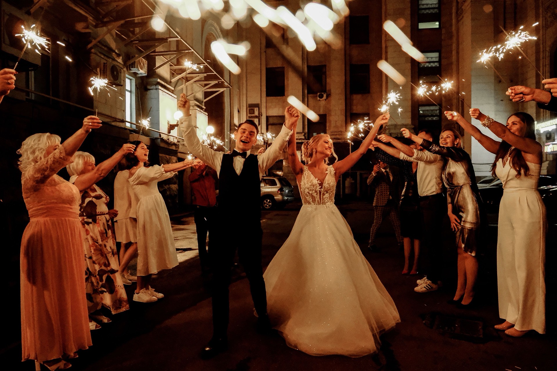 A cinematic night wedding sparkler send-off with the couple and guests